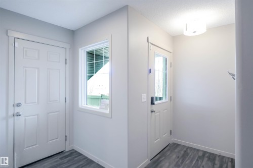 Entryway featuring a panelled door, a window with a view of greenery, and grey plank flooring - 1426 25 Avenue, Edmonton, AB - Indoor Photo Showing Other Room