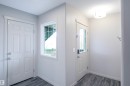 Entryway featuring a panelled door, a window with a view of greenery, and grey plank flooring - 1426 25 Avenue, Edmonton, AB  - Indoor Photo Showing Other Room 
