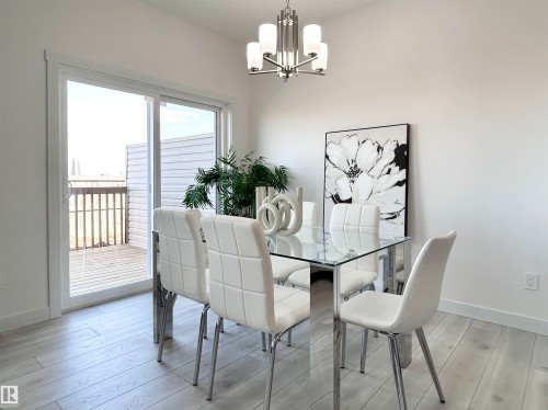 Dining area featuring light wood-style floors and a chandelier - 19634 29 Avenue, Edmonton, AB - Indoor Photo Showing Dining Room