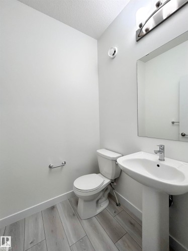 Half bathroom featuring wood tiled floors and a textured ceiling - 19634 29 Avenue, Edmonton, AB - Indoor Photo Showing Bathroom