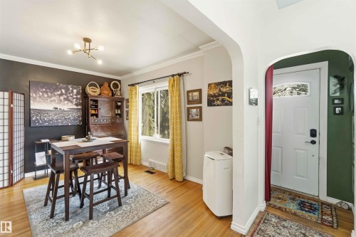 Hardwood-finish flooring extending into an arched doorway - 6036 106 Street, Edmonton, AB - Indoor Photo Showing Dining Room