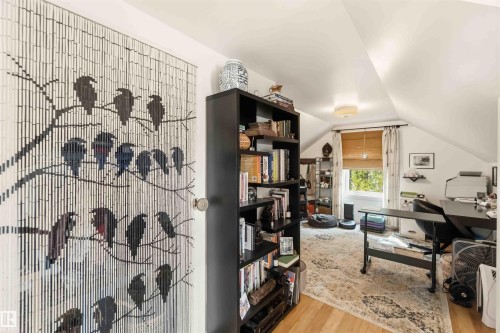 Bright attic room featuring sloped ceilings, a window with wood-finish blinds, wood-finish flooring, and a flush-mount ceiling light - 6036 106 Street, Edmonton, AB - Indoor Photo Showing Other Room