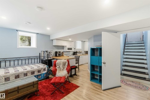 Lower level featuring recessed lighting, a modern kitchenette with white cabinetry and wood-finish countertops, wood-finish flooring, and a window providing natural light - 6036 106 Street, Edmonton, AB - Indoor