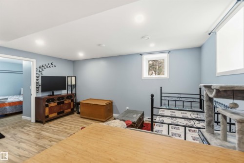 Spacious room with wood-finish flooring, recessed lighting, and light blue walls - 6036 106 Street, Edmonton, AB - Indoor