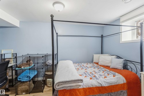 Light blue painted walls with wood-finish flooring - 6036 106 Street, Edmonton, AB - Indoor Photo Showing Bedroom
