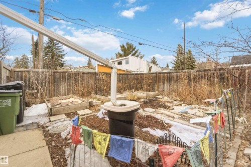 Wood plank fencing enclosing a backyard space featuring a downspout and rain barrel system - 6036 106 Street, Edmonton, AB - Outdoor