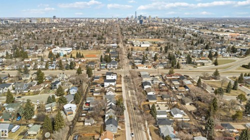 Aerial perspective showcasing a residential area with a prominent distant cityscape - 6036 106 Street, Edmonton, AB - Outdoor With View