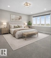 The property features a spacious room with light gray carpeting, a large window providing views of the outdoors, and a contemporary ceiling light fixture - 