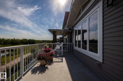 Balcony featuring a durable concrete surface, white metal railing, and extensive exterior siding - 