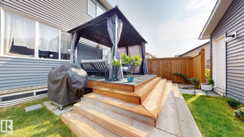 Exterior deck with multiple wooden steps, a gazebo with curtains, and a wooden fence - 1275 Chappelle Boulevard, Edmonton, AB 