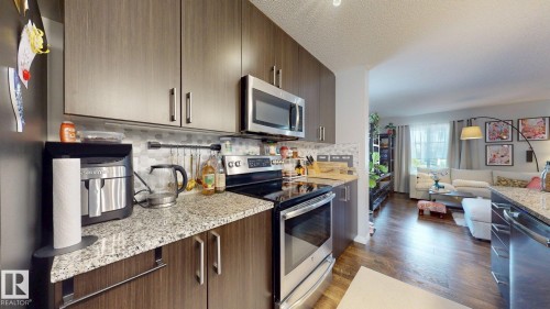 The kitchen features wood cabinetry, granite countertops, and stainless steel appliances - 1275 Chappelle Boulevard, Edmonton, AB 