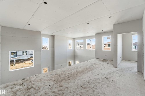 The property features an open-concept living space with numerous windows providing natural light - 33 Harley Way Nw, Spruce Grove, AB - Indoor Photo Showing Other Room