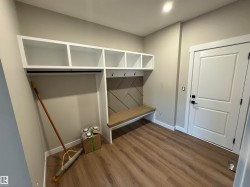 Built-in mudroom bench with storage cubbies and coat hooks - 