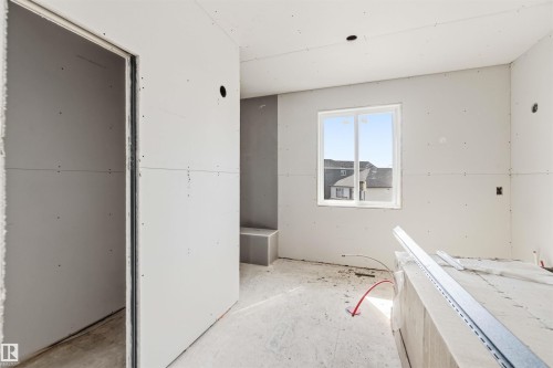 The property offers a room with a window providing views of nearby structures - 33 Harley Way Nw, Spruce Grove, AB - Indoor Photo Showing Other Room