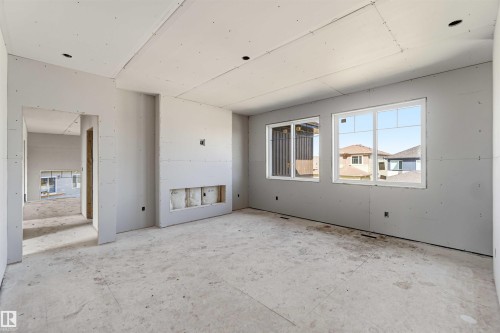 The interior space features drywall ready for finishing, an open doorway, and three windows providing natural light - 33 Harley Way Nw, Spruce Grove, AB - Indoor