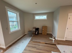 Neutral wall color complemented by white trim and wood-finish flooring - 