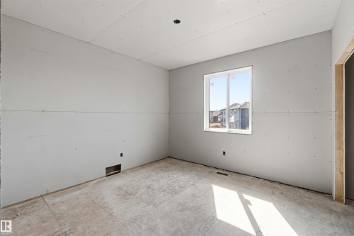 Room with newly installed drywall, an unfinished doorway, and a window providing natural light - 33 Harley Way Nw, Spruce Grove, AB - Indoor
