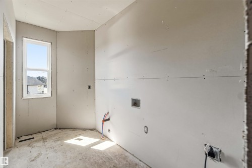 This room features a window providing natural light, bare walls, and visible electrical outlets - 33 Harley Way Nw, Spruce Grove, AB - Indoor Photo Showing Other Room