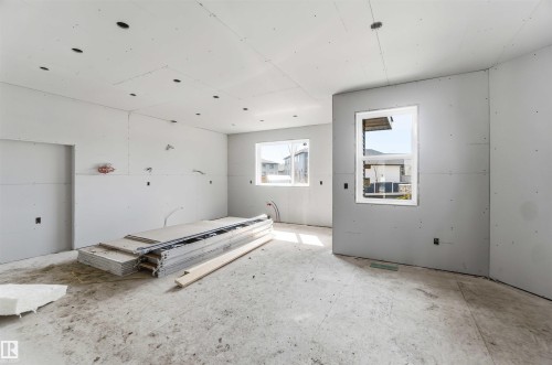 This expansive unfinished interior space offers a blank canvas for customization, featuring multiple windows providing natural light and visible electrical wiring for future fixtures - 33 Harley Way Nw, Spruce Grove, AB - Indoor