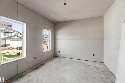 The room features two windows and drywall walls, ready for finishing - 33 Harley Way Nw, Spruce Grove, AB - Indoor Photo Showing Garage