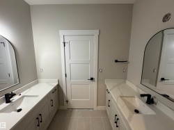 Dual vanity with integrated rectangular sinks, white countertops, and matte black fixtures - 