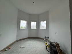 Bay window alcove featuring three individual windows with white trim, smooth white walls, and a level ceiling - 