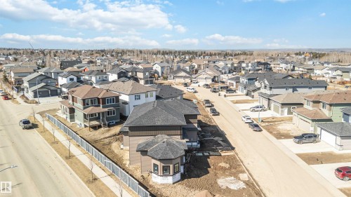 Aerial view of a residential neighbourhood featuring a paved street, sidewalks, and a variety of detached properties with attached garages - 33 Harley Way, Spruce Grove, AB - Outdoor With View