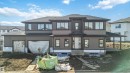 The property features a dark-toned roof, light brown siding, and dark window frames - 33 Harley Way Nw, Spruce Grove, AB  - Outdoor With Facade 