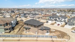 This property features a newly constructed residence with a dark shingled roof, offering a view of the surrounding residential area - 