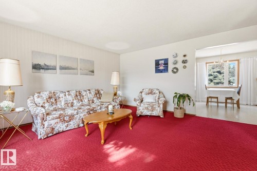 The living area features a red carpet and light-colored walls - 10716 52 Avenue, Edmonton, AB - Indoor Photo Showing Living Room