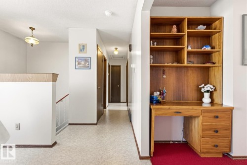 The property features a built-in wooden desk with shelving, providing a dedicated workspace - 10716 52 Avenue, Edmonton, AB - Indoor