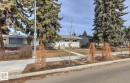 The property features a front yard with a walkway leading to the entrance, mature evergreen trees, and additional landscaping - 10716 52 Avenue, Edmonton, AB  - Outdoor 