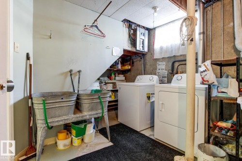 Utility space featuring a washer and dryer, a utility sink, and a window providing natural light - 10716 52 Avenue, Edmonton, AB - Indoor Photo Showing Laundry Room