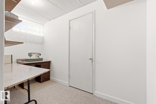 This room features light-colored walls, a drop ceiling, and light-colored flooring - 10716 52 Avenue, Edmonton, AB - Indoor Photo Showing Other Room