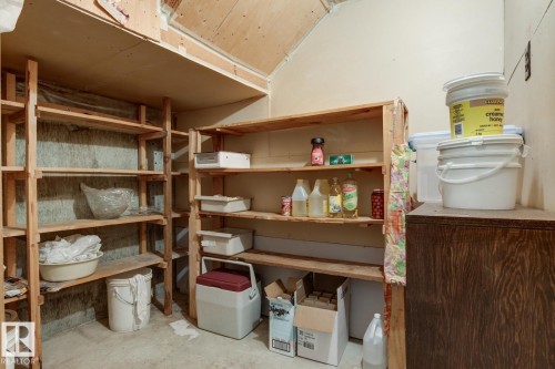 This area features extensive wooden shelving providing ample storage space - 10716 52 Avenue, Edmonton, AB - Indoor