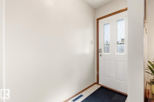 Welcoming entryway featuring a white door with decorative glass inserts and wood trim - 10716 52 Avenue, Edmonton, AB - Indoor Photo Showing Other Room