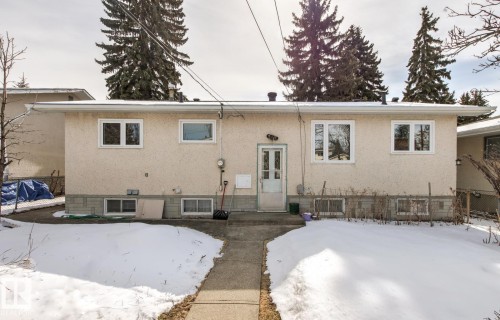 The property features a stucco exterior with multiple windows and a central entrance - 10716 52 Avenue, Edmonton, AB - Outdoor
