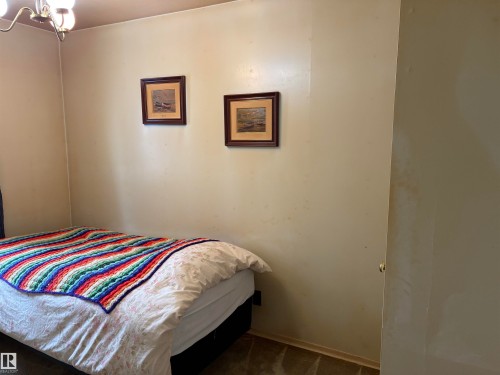 This room features a ceiling-mounted light fixture and a framed artwork on the wall - 10916 151 Street, Edmonton, AB - Indoor Photo Showing Bedroom