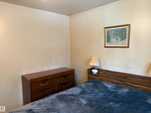 This bedroom features light-colored walls and a wooden headboard, creating a neutral canvas - 10916 151 Street, Edmonton, AB - Indoor Photo Showing Bedroom