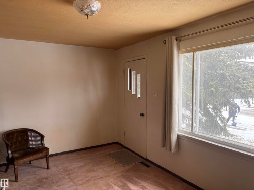 Entryway featuring a decorative ceiling light fixture, a large window with white curtains, and a door with frosted glass inserts - 10916 151 Street, Edmonton, AB - Indoor Photo Showing Other Room