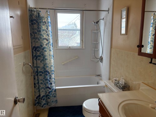 This bathroom features a full bathtub with a showerhead and a window - 10916 151 Street, Edmonton, AB - Indoor Photo Showing Bathroom