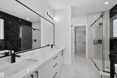 Bathroom featuring a double vanity with white countertops, matte black faucets, and a large mirror - 190 Elliott Wynd, Fort Saskatchewan, AB - Indoor Photo Showing Bathroom