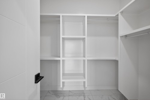 The property features an extensive walk-in closet with built-in shelving and hanging rods, providing ample storage - 190 Elliott Wynd, Fort Saskatchewan, AB - Indoor With Storage