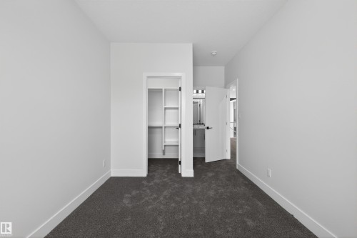 This room features plush dark carpeting and white walls, offering a neutral palette - 190 Elliott Wynd, Fort Saskatchewan, AB - Indoor Photo Showing Other Room