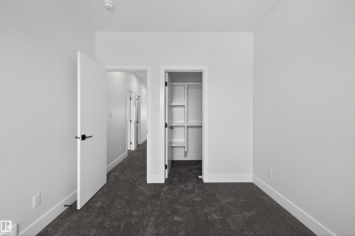 This room features white walls, dark gray carpet, and white trim - 190 Elliott Wynd, Fort Saskatchewan, AB - Indoor Photo Showing Other Room