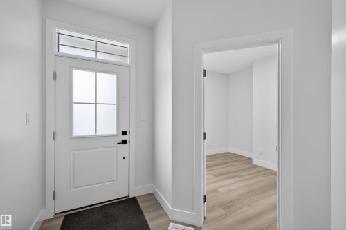 Entryway featuring a white door with frosted glass panels, a transom window, and light-toned flooring - 190 Elliott Wynd, Fort Saskatchewan, AB - Indoor Photo Showing Other Room