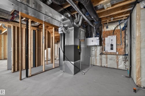 The property features an unfinished basement with exposed wooden framing and ductwork, a concrete floor, and visible electrical panels - 190 Elliott Wynd, Fort Saskatchewan, AB - Indoor Photo Showing Basement