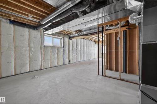 Unfinished lower level offering extensive potential for custom development, featuring a concrete floor, exposed ceiling joists, and visible insulation - 190 Elliott Wynd, Fort Saskatchewan, AB - Indoor Photo Showing Basement