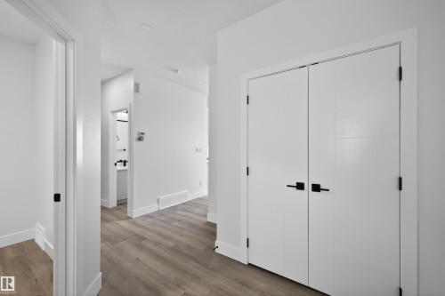 The interior features modern white doors with matte black hardware, complemented by light-colored flooring - 190 Elliott Wynd, Fort Saskatchewan, AB - Indoor Photo Showing Other Room