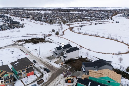 Aerial view highlighting the property's proximity to a winding path and a snow-covered natural area - 190 Elliott Wynd, Fort Saskatchewan, AB - Outdoor With View